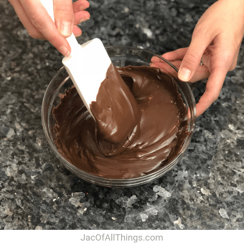 The first step in making hot chocolate on a stick is to place chocolate in a microwave safe bowl and heat.